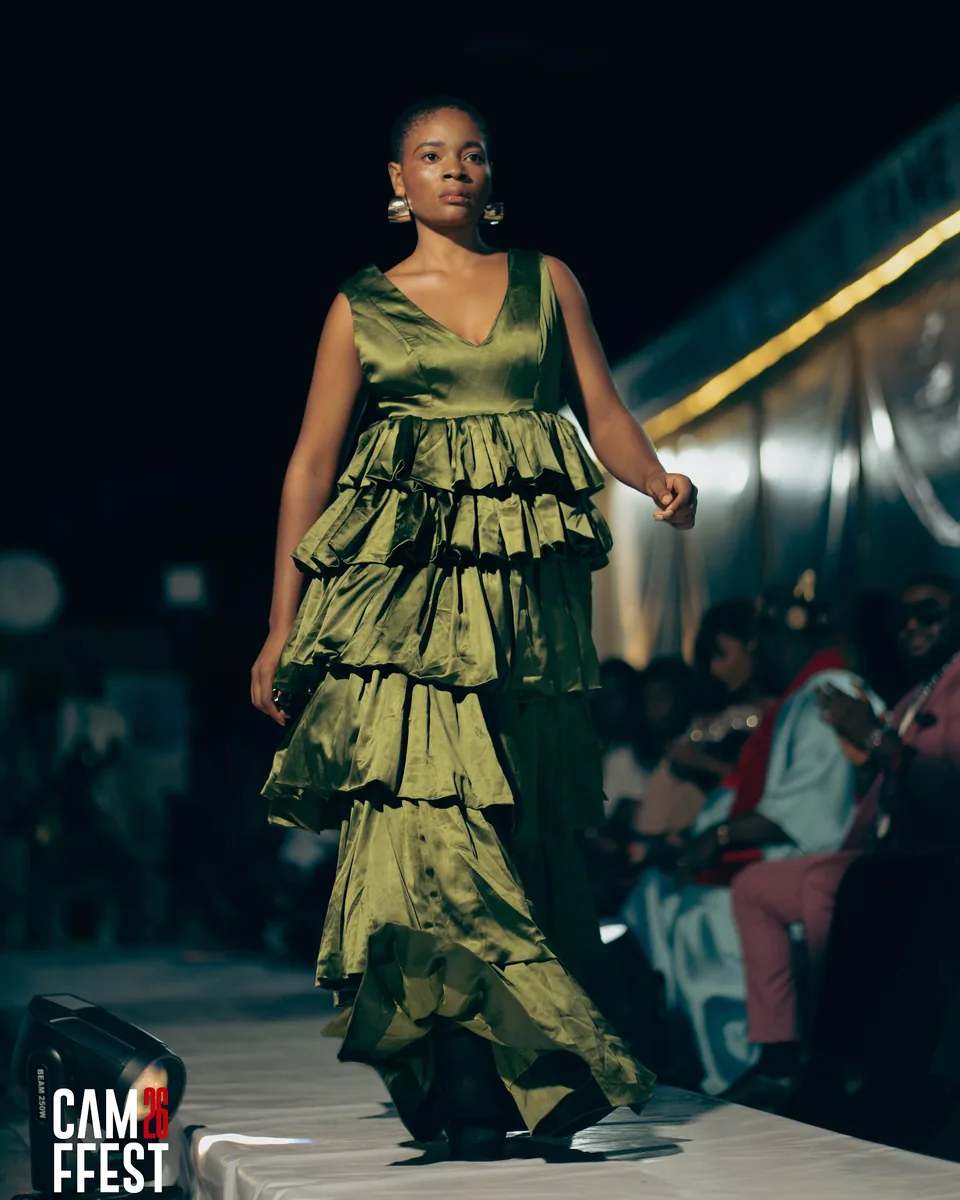 Model in an olive ruffled gown on the runway
