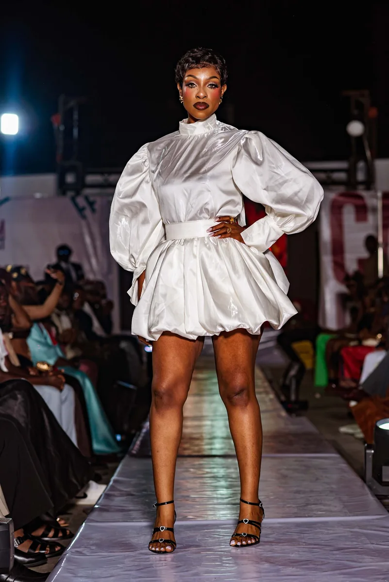 Model in a white puff-sleeve dress