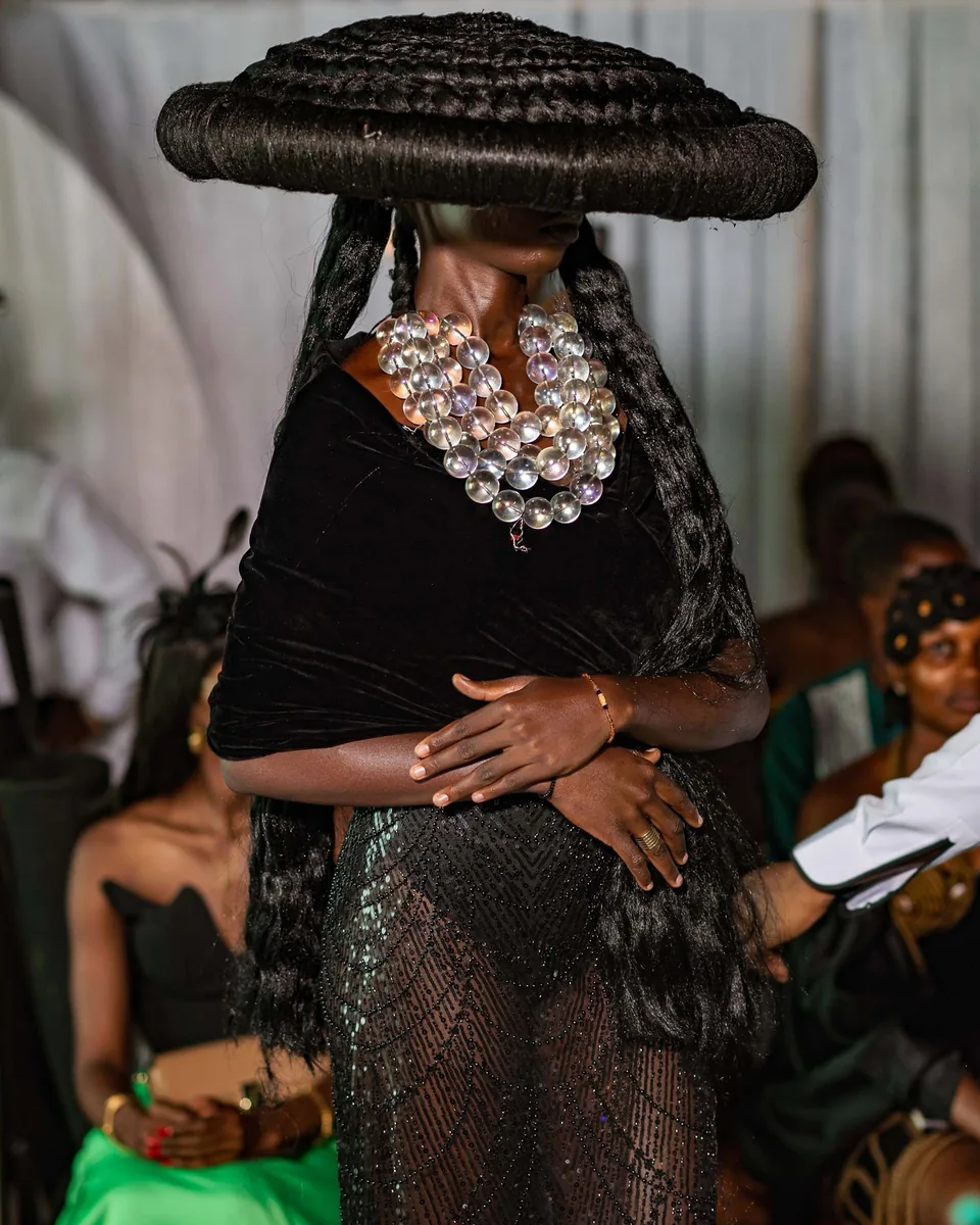 Model in a wide braided hat and shell necklace